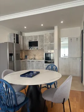 Dining area with a round table and chairs integrated with the kitchen. - image 3