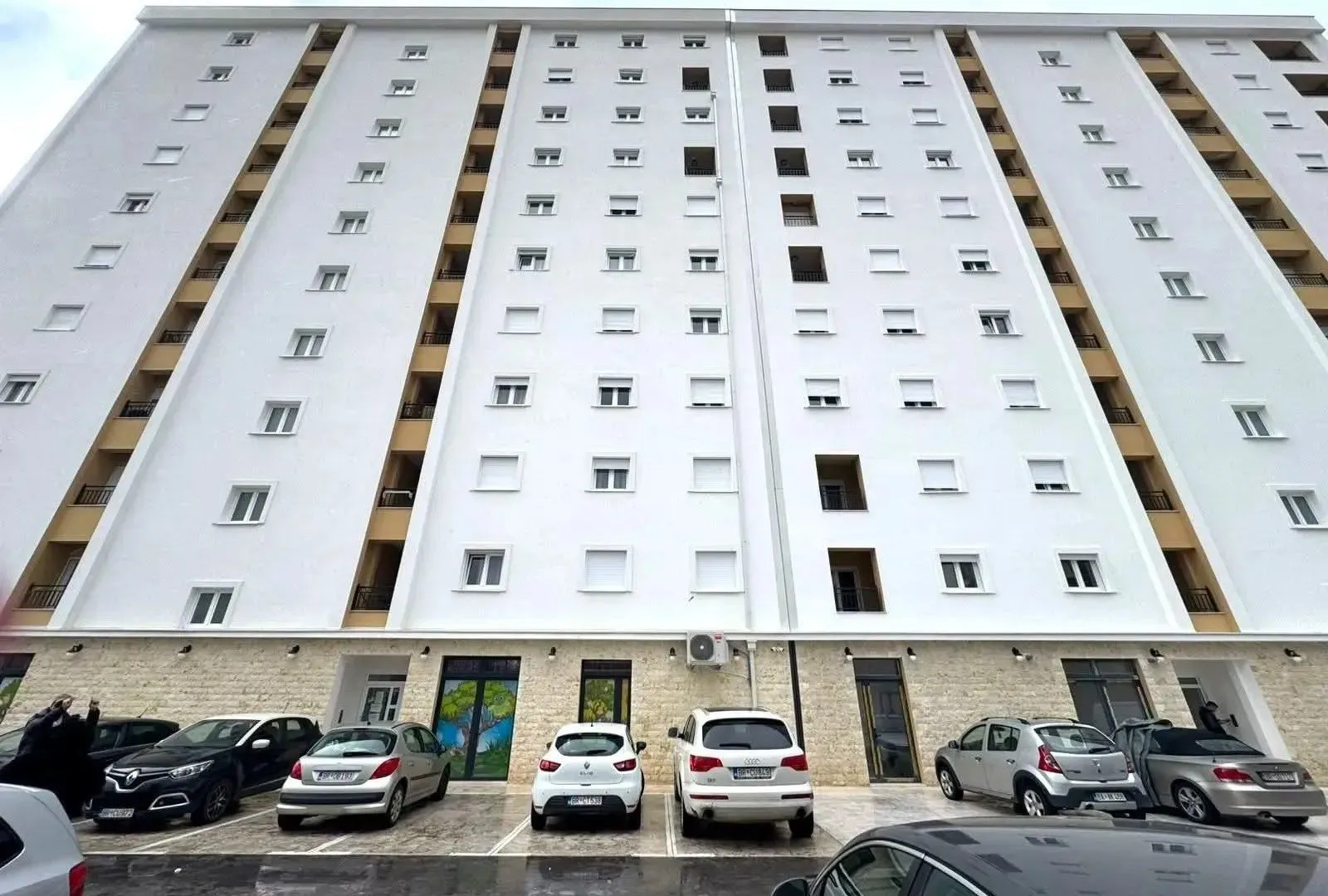 View of the residential building facade with parking in front.