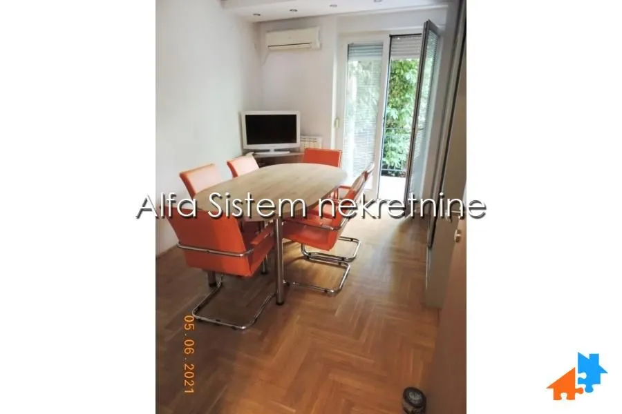Living room with a dining table and orange chairs.