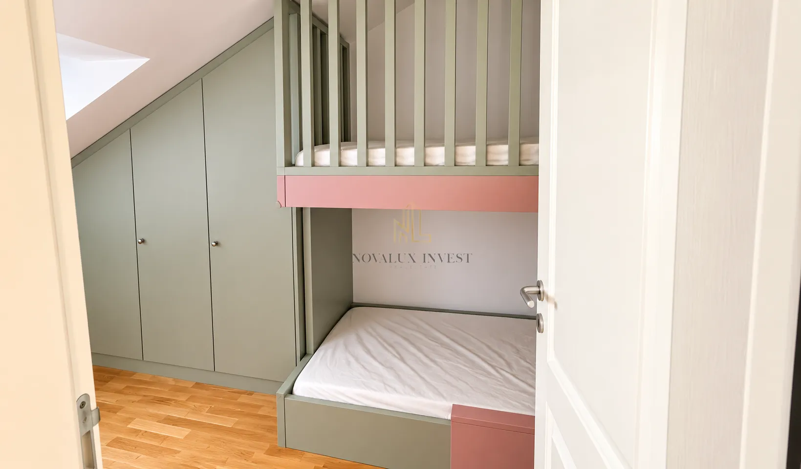 Children's bedroom with bunk beds and a built-in wardrobe under the slanted ceiling.