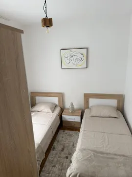 Manja spavaća soba sa dva odvojena kreveta i noćnim ormarićem. - image 8