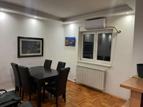 Dining area with a black table and chairs, hardwood flooring and a window. - image 3