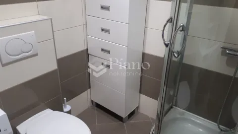 View of the bathroom with sanitary fixtures, a cabinet, and a shower cabin. - image 5