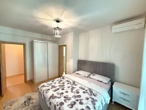 Furnished bedroom with a double bed, wardrobe, and air conditioning. - image 9