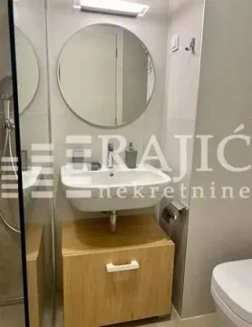 Moderno kupatilo sa umivaonikom, drvenim ormarićem i ogledalom. - image 8