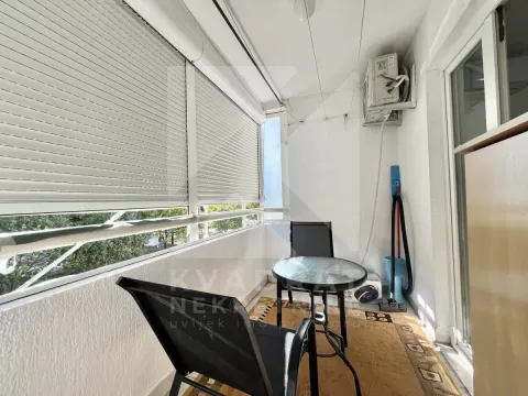 Enclosed balcony with a small table and chairs. - image 7