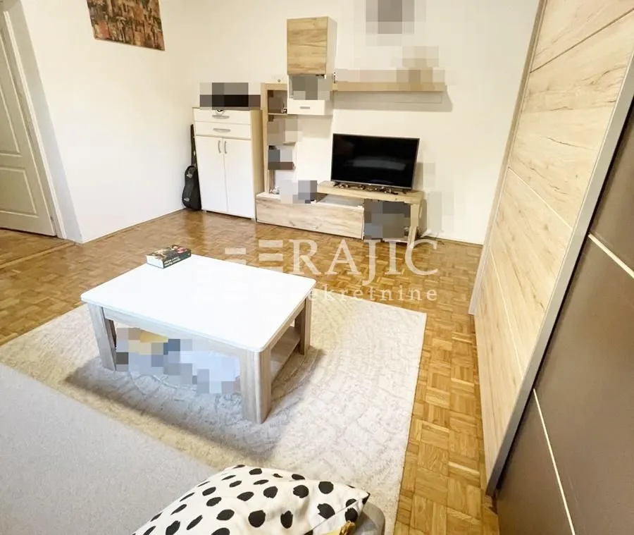Living room with furniture, TV unit, and parquet flooring.