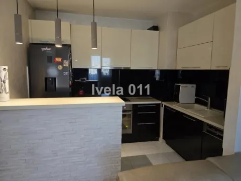 Manja kuhinja sa svetlim gornjim i tamnim donjim elementima, ugradnim aparatima i šankom. - image 8