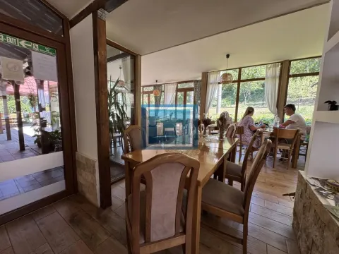 Spacious dining area with a wooden table and chairs and a view of nature. - image 32