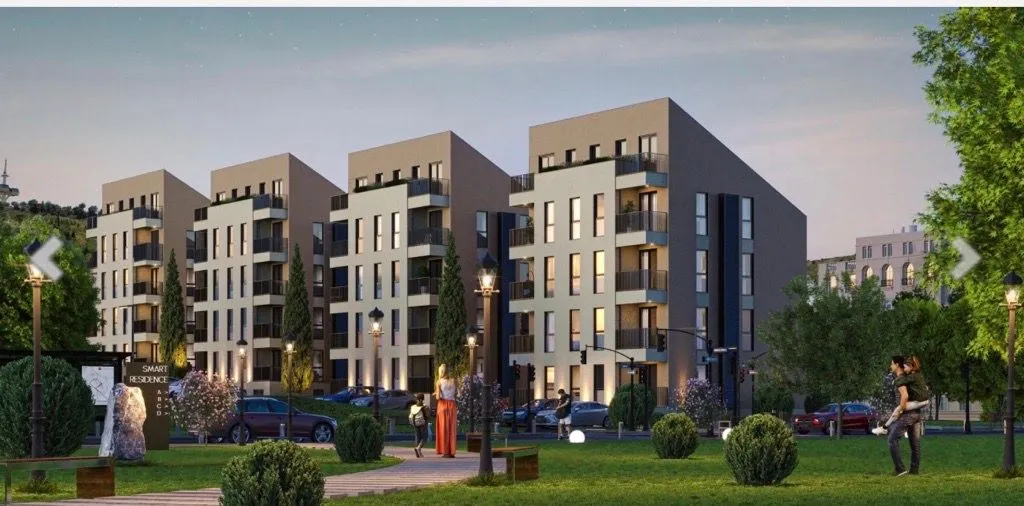 Spoljašnji izgled modernih stambenih zgrada sa uređenim parkom i zelenilom.