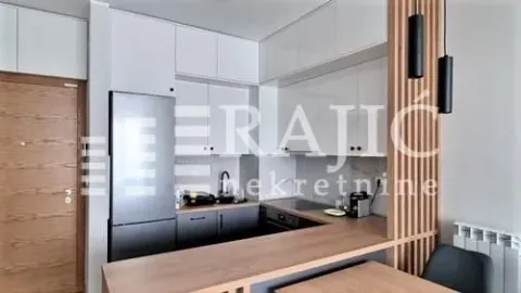 Modern kitchen with white units and wooden details. - image 4
