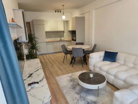 Living room with sofa, dining area, and kitchen in the background. - image 2