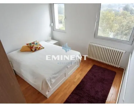 Bedroom with a double bed, wooden flooring, and windows. - image 12