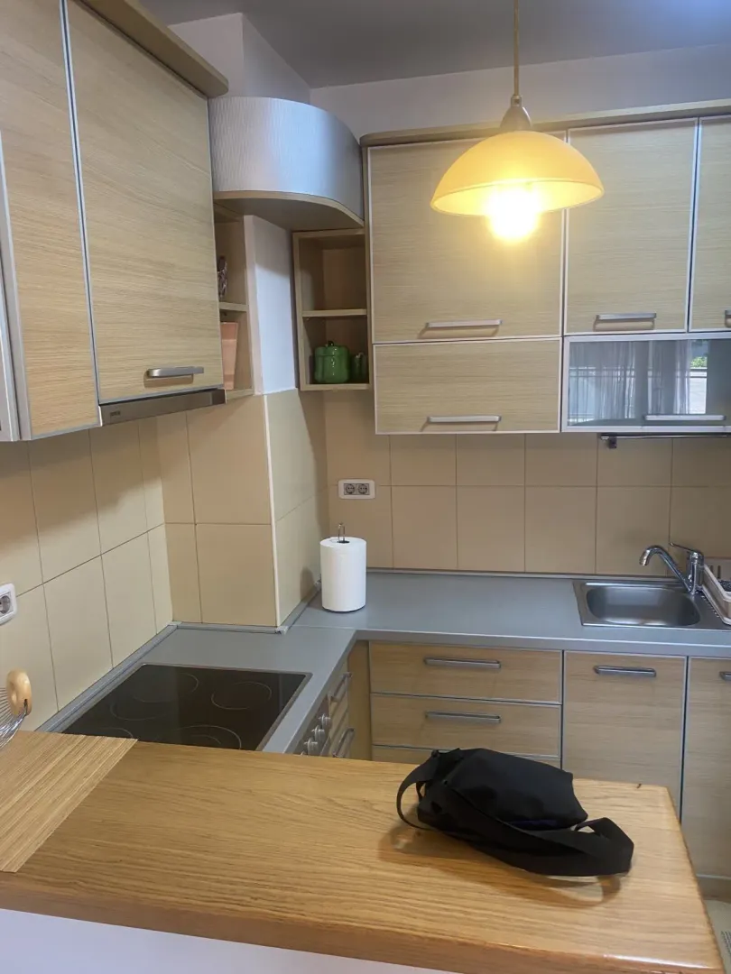 Bright kitchen with wooden cabinets, a built-in hob, and a sink.