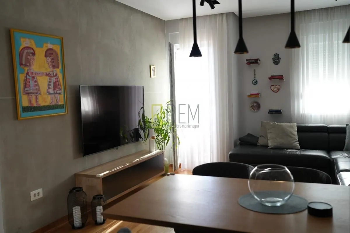 Living room with a sofa, TV, and dining table.