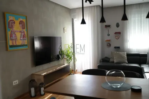 Living room with a sofa, TV, and dining table. - image 8