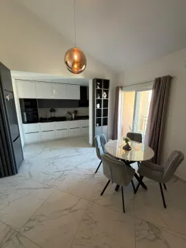 Modern kitchen with dining area and marble-effect tiles. - image 2