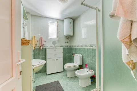 Kupatilo obloženo zelenim pločicama sa umivaonikom, toaletom, bideom i bojlerom. - image 14