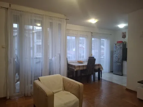 Svijetla dnevna soba sa trpezarijskim stolom i foteljom u prvom planu. - image 3