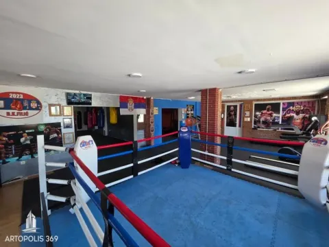 Interior of a boxing gym with a ring and exercise equipment. - image 2