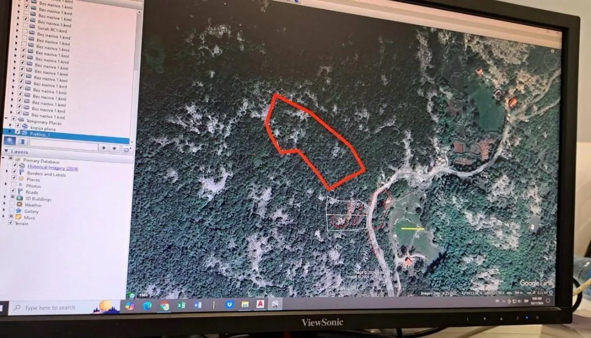 Prikaz satelitskog snimka terena sa ucrtanim granicama parcele na ekranu računara.