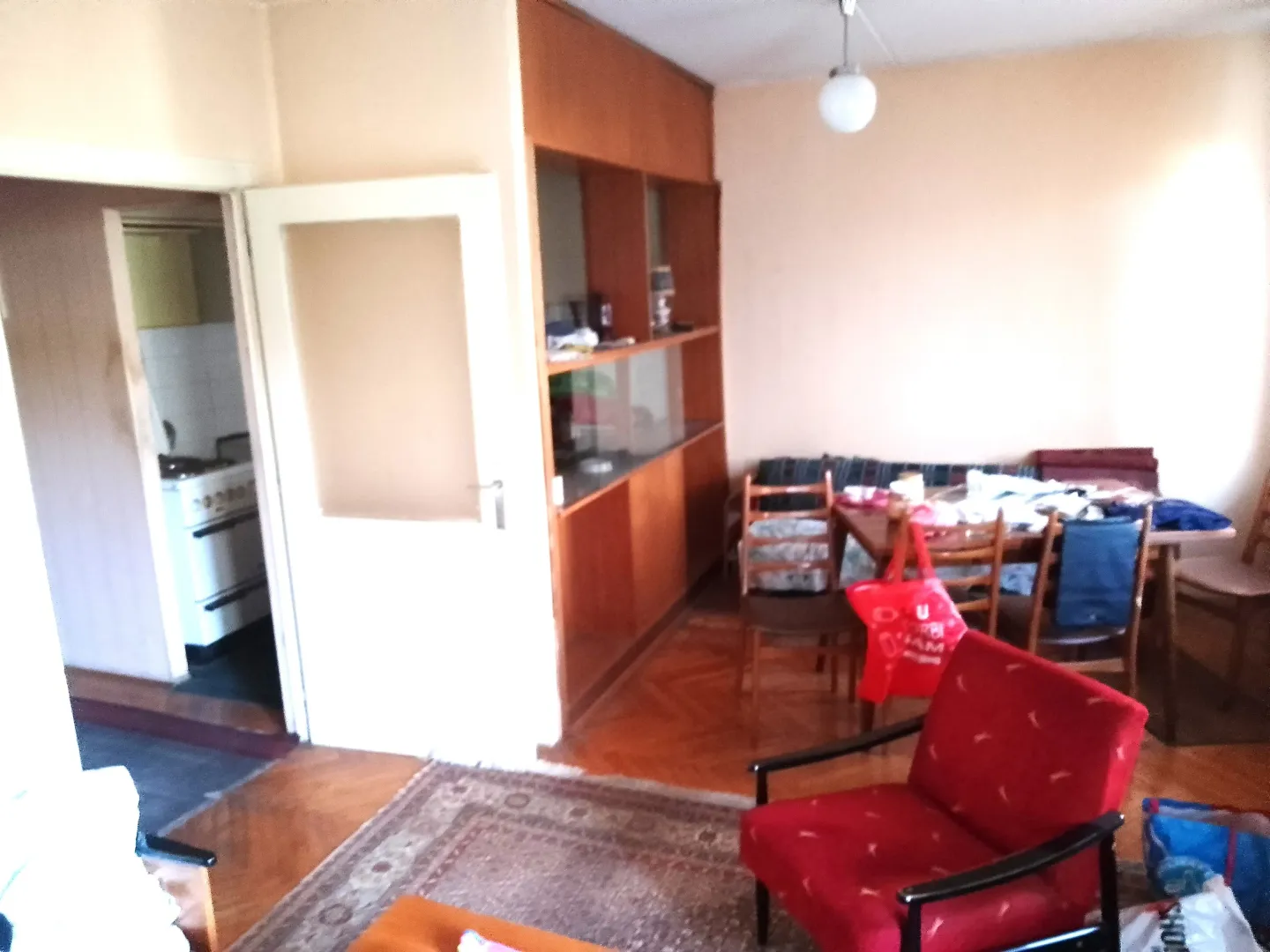 Dnevna soba sa trpezarijom i namještajem starije generacije.