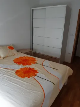 Bright bedroom featuring a double bed and a white wardrobe. - image 5
