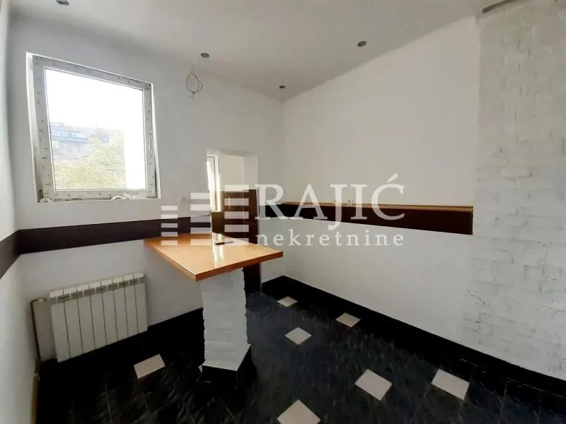 Smaller empty kitchen with a bar counter and a window.