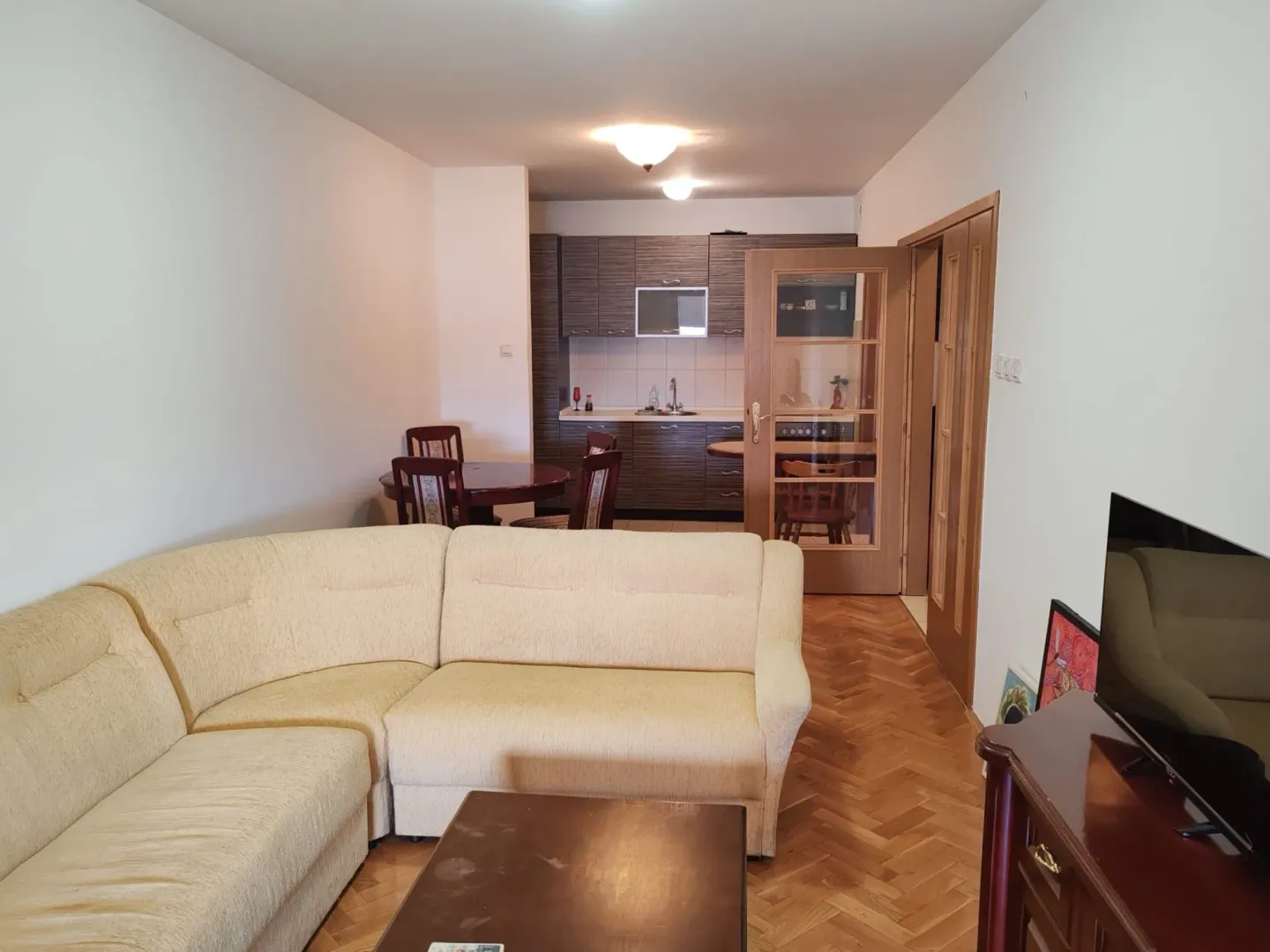 Living room with a sofa and a view towards the dining area and kitchen.