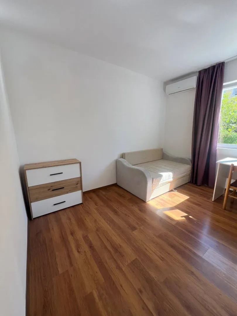 Furnished bedroom with a bed, dresser, and desk.
