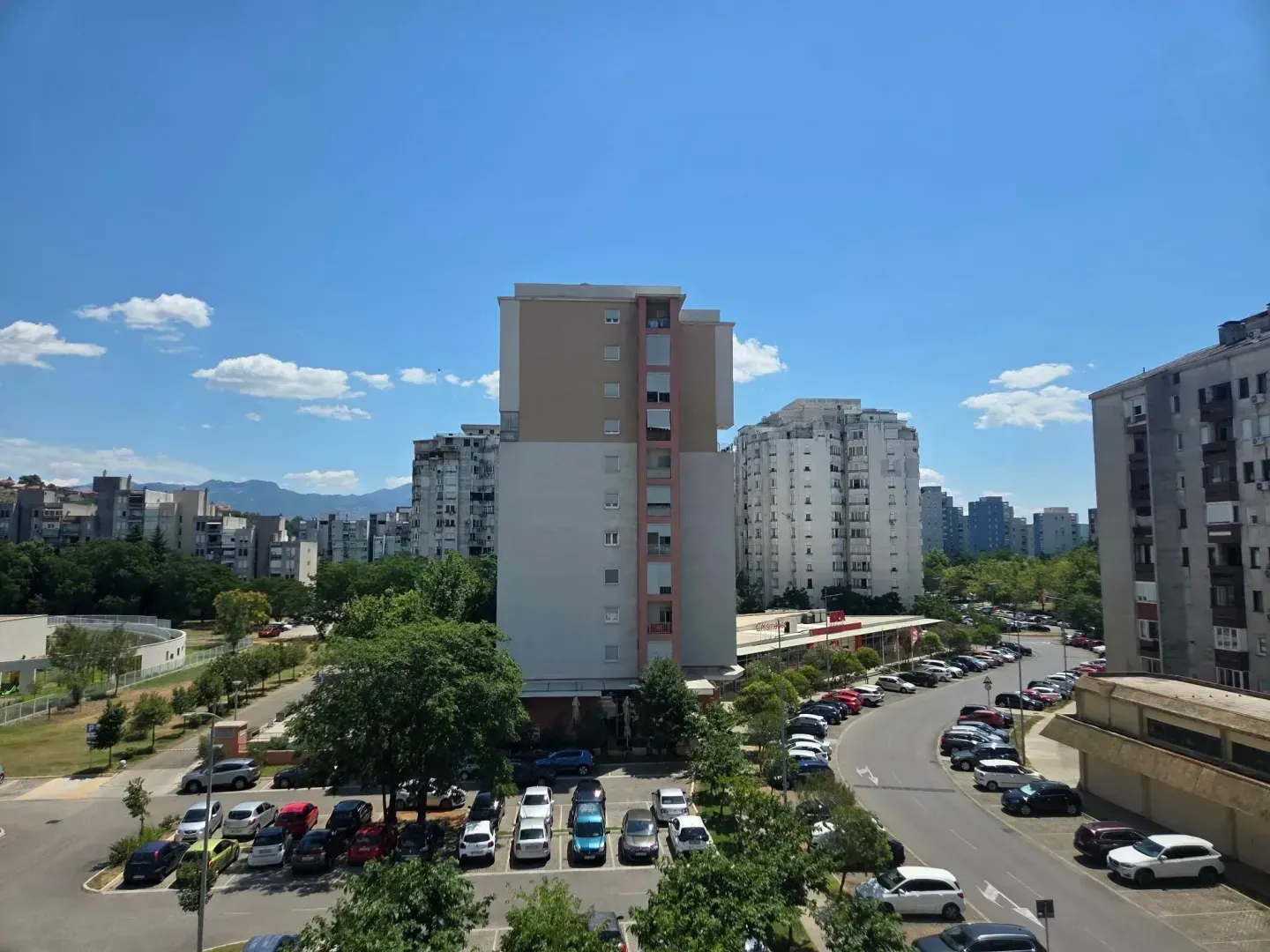 View from the terrace of surrounding residential buildings and parking lot.