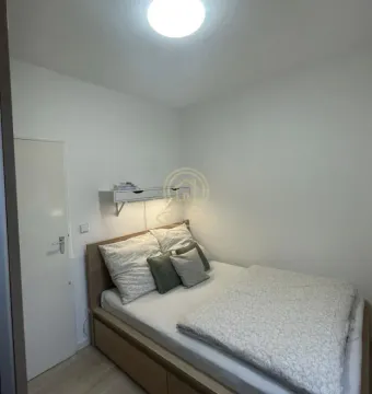 Manja spavaća soba sa bračnim krevetom i belim zidovima. - image 8