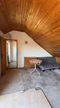 Potkrovlje sa drvenom krovnom konstrukcijom, garniturom za sedenje i oštećenim podom. - image 7