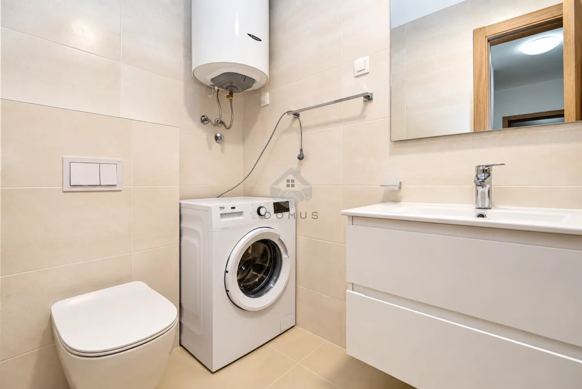 Bathroom equipped with a toilet, sink, washing machine, and water heater.