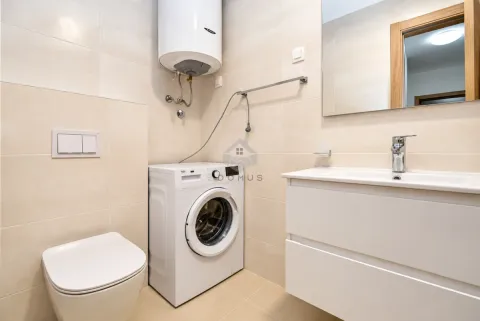 Bathroom equipped with a toilet, sink, washing machine, and water heater. - image 25