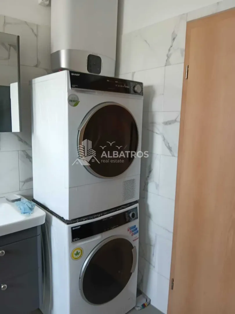 Bathroom with a washer-dryer unit and a water heater.