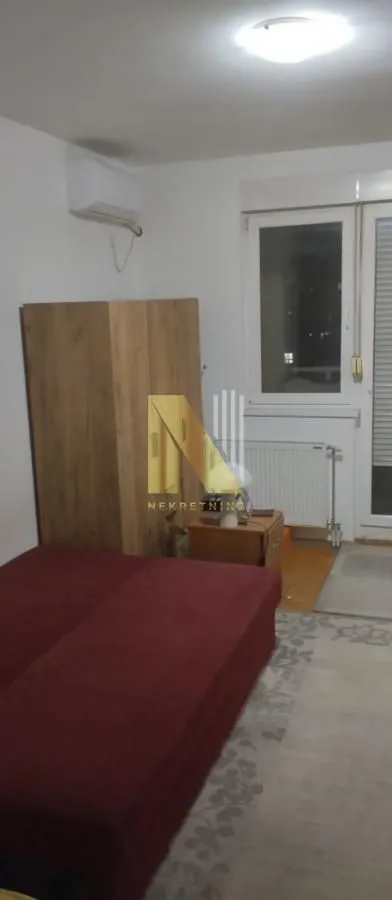 Nameštena spavaća soba sa krevetom i ormarom.