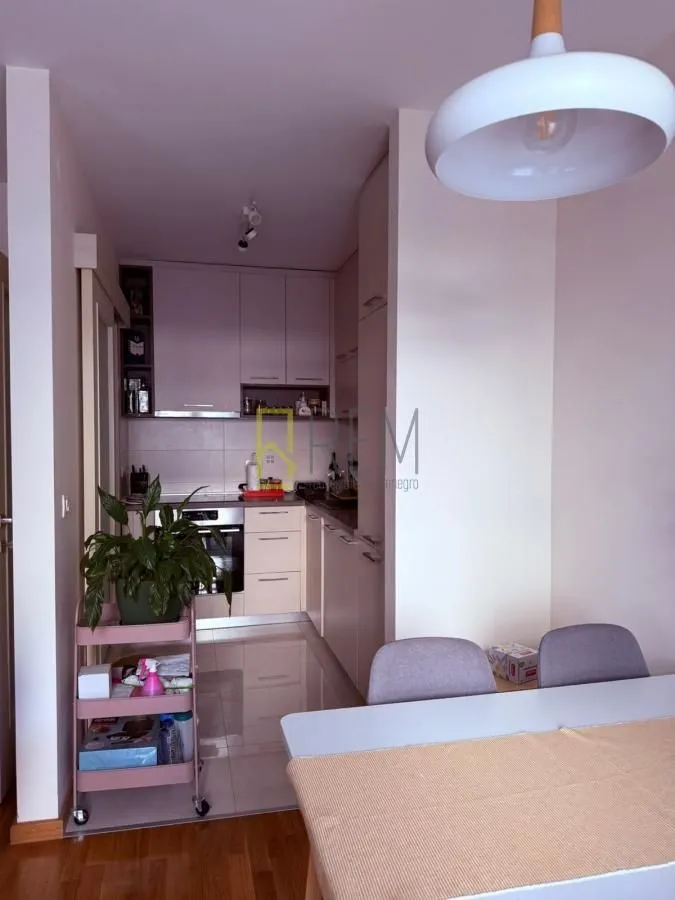 Small kitchen with light-colored cabinetry and a dining table in the foreground.