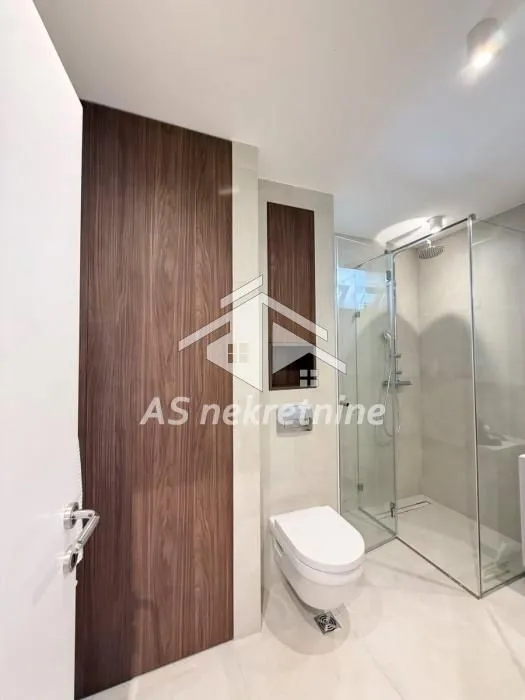 Moderno kupatilo sa tuš kabinom i visećom wc šoljom.