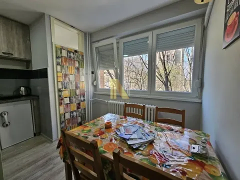 Trpezarija sa stolom i stolicama smeštena pored kuhinje sa prozorom. - image 6
