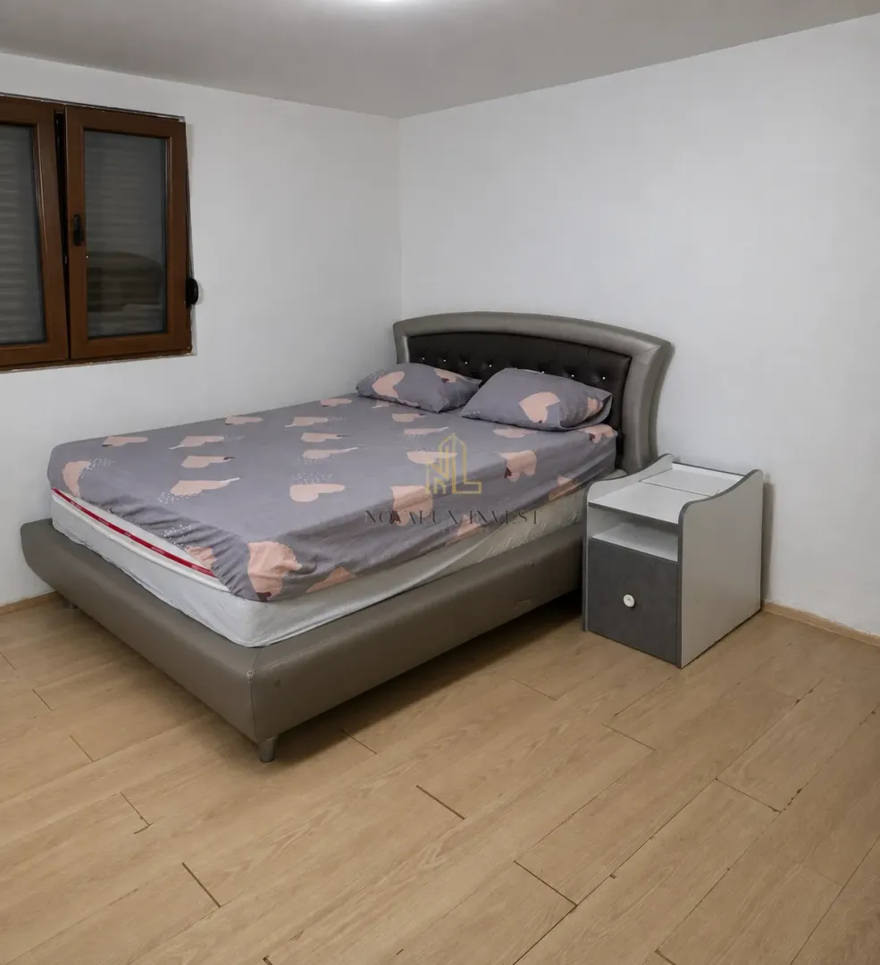 Furnished bedroom with a double bed and a bedside table.