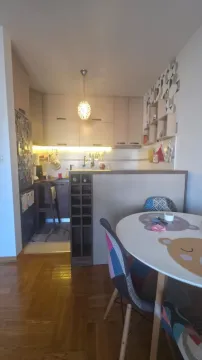 Manja kuhinja sa trpezarijskim stolom i stolicama u stanu. - image 2