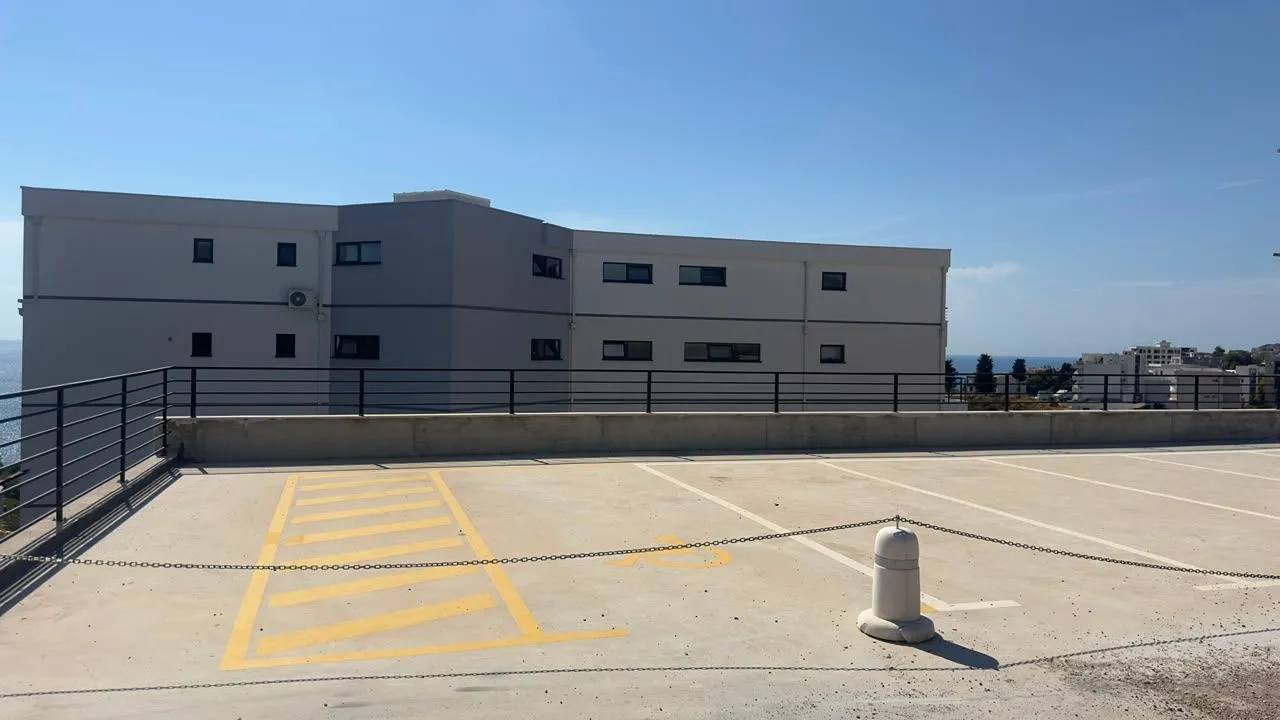 Otvoreni parking prostor ispred stambene zgrade.