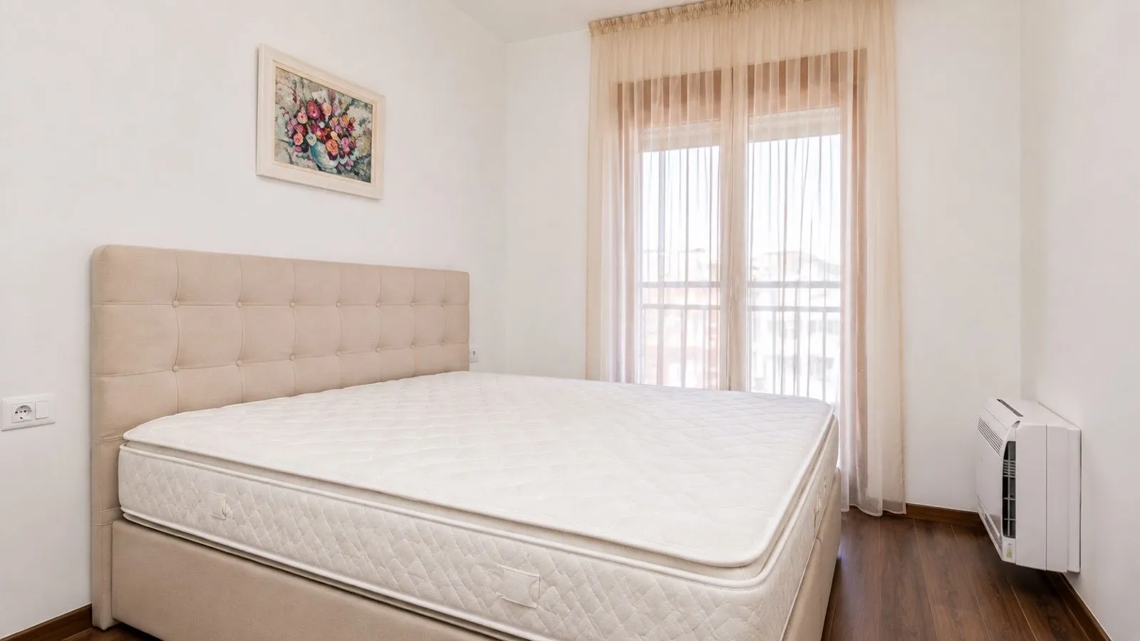 Bright bedroom with a double bed and a window.