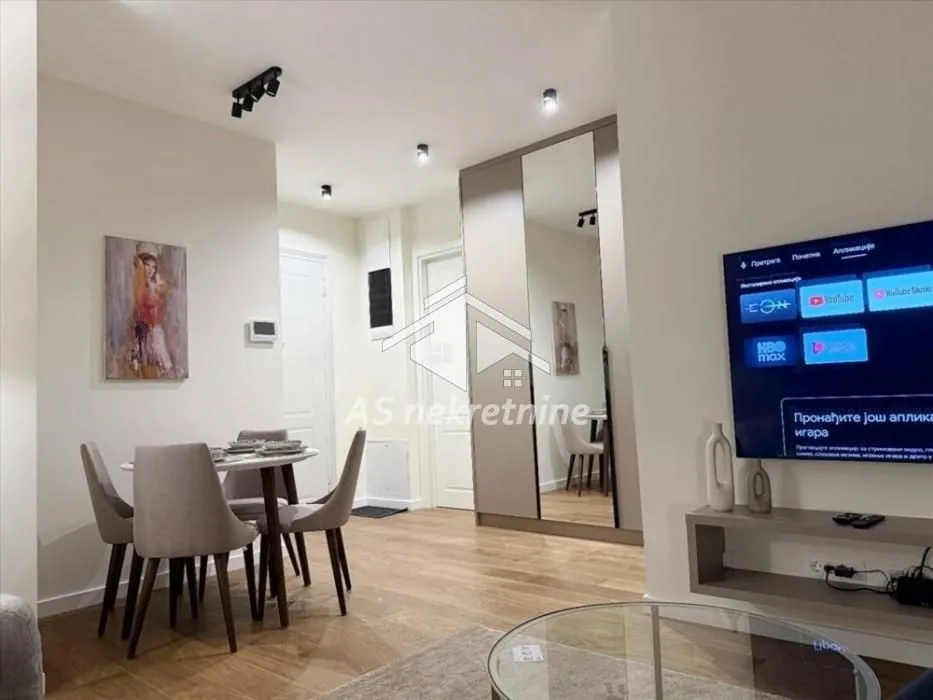 Living room with dining area, seating and a built-in mirrored wardrobe.