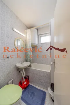 Manje kupatilo sa kadom, umivaonikom i wc šoljom obloženo keramičkim pločicama. - image 13