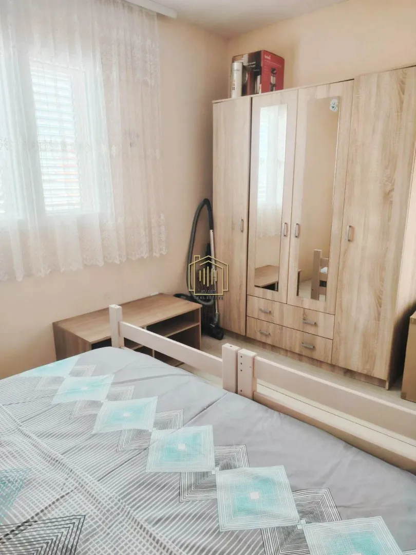 Furnished bedroom with a large wardrobe and a window.