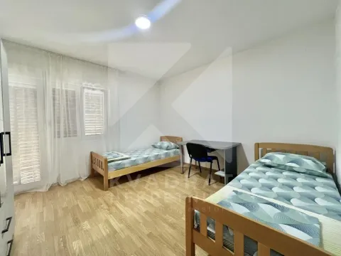 Spavaća soba sa dva kreveta i radnim stolom. - image 8