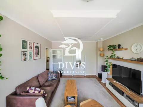 Living room with a corner sofa, TV, and wooden coffee table. - image 6