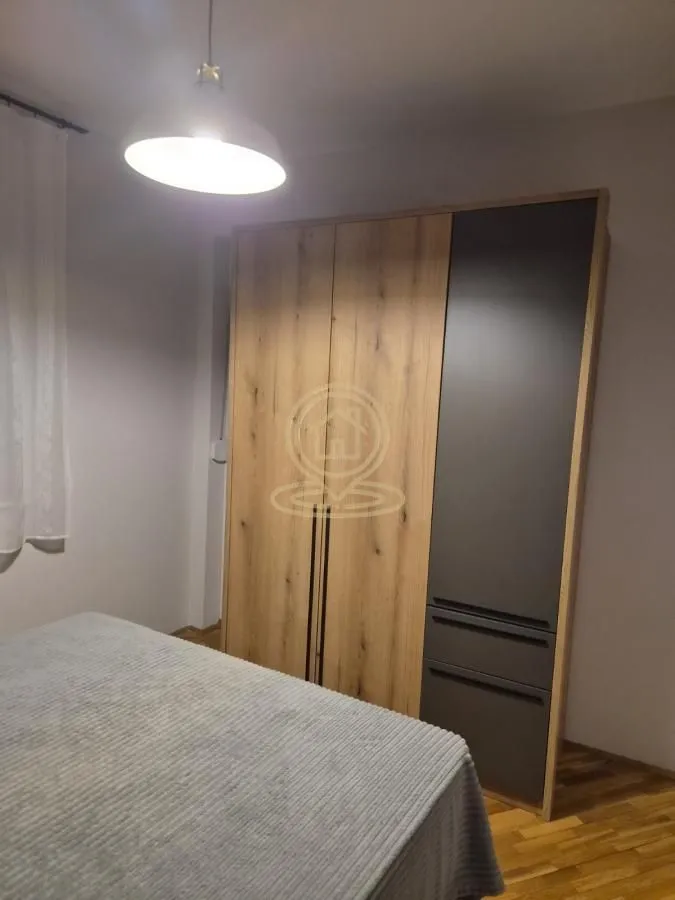 Spavaća soba sa krevetom i velikim ugrađenim garderoberom.